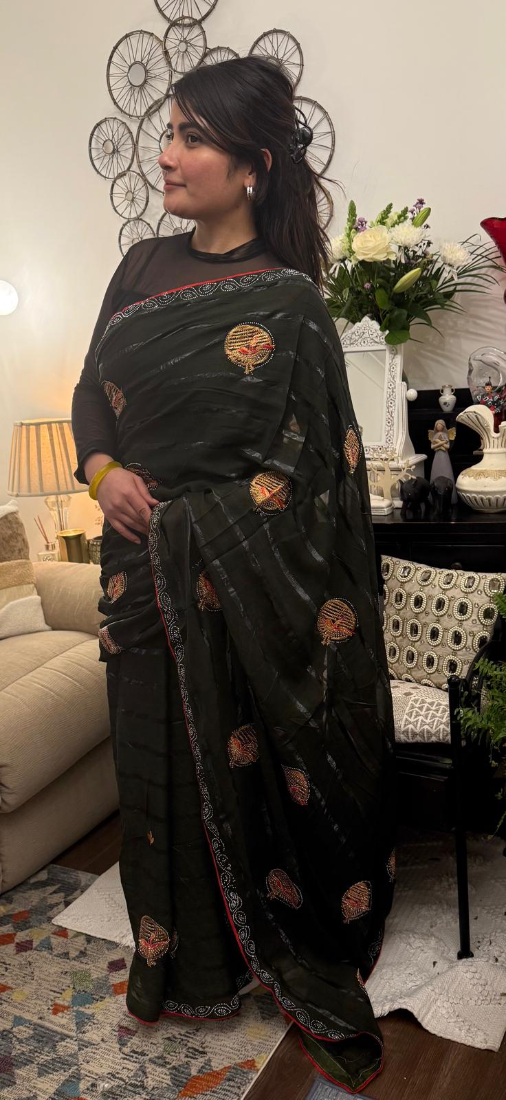 A mud grey chiffon saree adorned with delicate stone work,intricately arranged in graceful leafy ,motifs,lending it a refined and sophisticated charm.£55