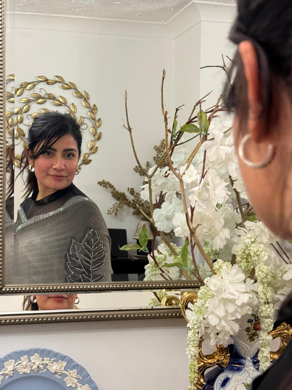 A mud grey chiffon saree adorned with delicate stone work,intricately arranged in graceful leafy ,motifs,lending it a refined and sophisticated charm.£55