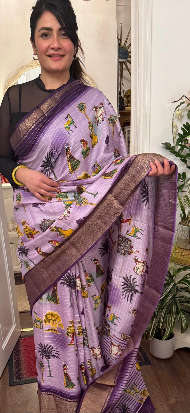 A lavender silk saree with a rich plum border delicately detailed with subtle zari work throughout. Showcasing ethnic, folk- inspired drawings that reflects culture and place with timeless pride. £80 tbc