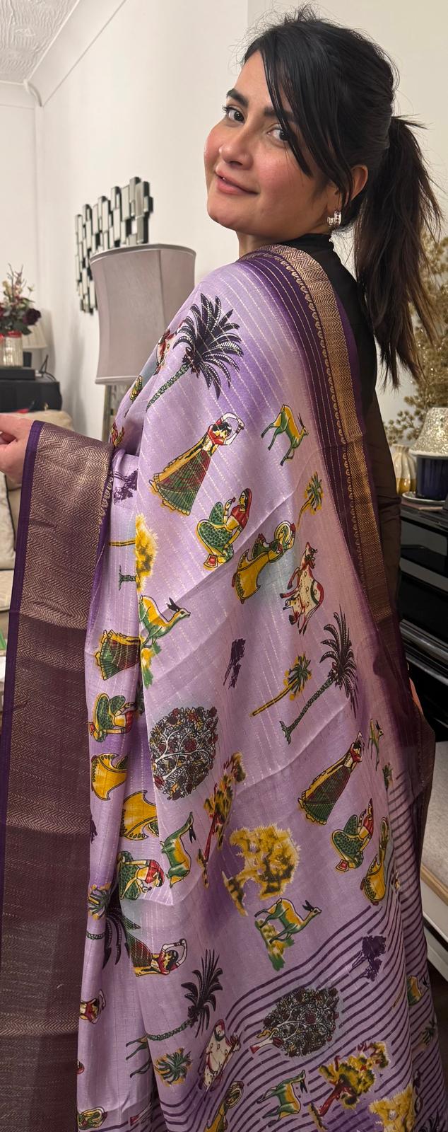 A lavender silk saree with a rich plum border delicately detailed with subtle zari work throughout. Showcasing ethnic, folk- inspired drawings that reflects culture and place with timeless pride. £80 tbc