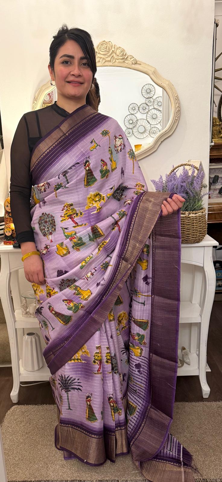 A lavender silk saree with a rich plum border delicately detailed with subtle zari work throughout. Showcasing ethnic, folk- inspired drawings that reflects culture and place with timeless pride. £80 tbc