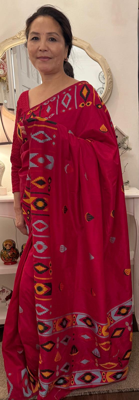 A hot pink raw silk saree featuring subtle geometrical patterns in the traditional Dhaka print, showcasing timeless craftsmanship with a contemporary appeal £70