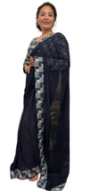 A midnight blue georgette saree beautifully detailed with Dhaka print border in a lighter tonal shade. Complimented by a matching blouse.This ensemble is truly unique and graceful, effortlessly maintaining a smart and elegant appeal. £135